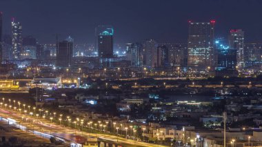 Göller gece zaman aşımına sahip Golf sahası yakınındaki evlere ve villalara havadan bak. Jumeirah köy daire ilçesinde Şantiye. Yolda trafik