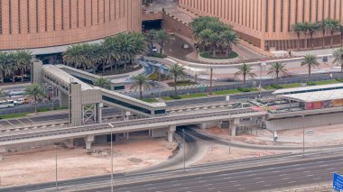 Dubai, Bae Dubai Marina tramvay durağı timelapse gelen yaya köprüsü ile alışveriş merkezi yakınında trafik havadan üst görünümü. Yolda trafik