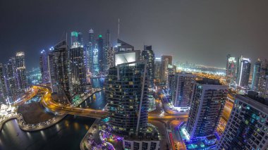 Dubai Marina konutlarının panoramik hava manzarası ve rıhtım manzaralı gökdelenler. Köprüde trafik vardı. Yüzen tekneler ve yatlar