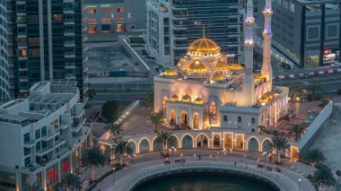 Dubai Marina ve Mohammed Bin Ahmed Almulla Camii 'nin modern konut mimarisi günden geceye geçiş zamanı, Birleşik Arap Emirlikleri. Bir yolda gezinti ve trafik