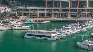 Dubai Marina Limanı 'ndaki rıhtım güvertesi, zaman ayarlı. Kanalda yüzen tekne ve yatlar. Dubai, Birleşik Arap Emirlikleri