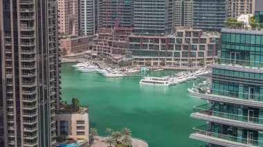 Dubai Marina 'da gökdelenleri olan bir rıhtım gezisi. Kanalda yüzen tekne ve yatlar. Dubai, Birleşik Arap Emirlikleri