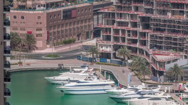 Dubai Marina Limanı 'ndaki rıhtım güvertesi, zaman ayarlı. Kanalda yüzen tekne ve yatlar. Dubai, Birleşik Arap Emirlikleri