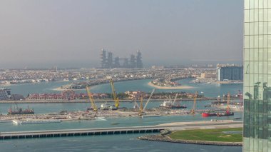 Palm Jumeirah adam havadan görünümü gün batımı zaman atlamalı önce Jbr ilçesinden ada yaptı. Dubai, Bae. Tekne ve yatlarla yeni liman terminalinin şantiyesi