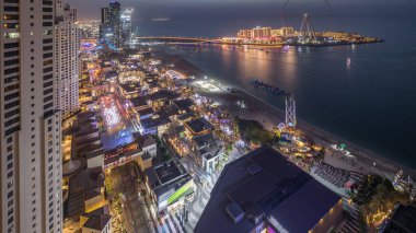 Waterfront genel bakış Jumeirah Beach Residence Jbr silueti ışıklı gökdelenler ile gece geçiş timelapse gün havadan. Yukarıdan mağazalar, restoranlar ve diğer eğlence