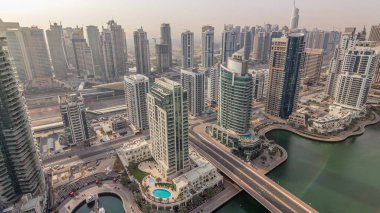 Dubai Marina ve Jlt sabah timelapse havadan üst görünümü. Dubai, Bae gün doğumundan sonra yüzen yatlar ve tekneler ile gezinti ve kanal. Modern kuleler ve yolda trafik