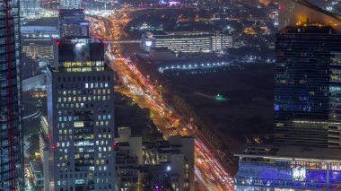 Al Saada caddesinde, Dubai, BAE 'deki DIFC gece zaman çizelgesi yakınlarındaki kavşak trafiğinin Skyline görüntüsü. Finans merkezindeki gökdelenler şehir merkezindeki yukarıdan hava manzarası