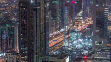 Sheikh Zayed Road ve Difc hava gece zaman aşımına Dubai, Bae yakınındaki binaların Silueti. Finans merkezi ve şehir merkezinde müze şantiye ile modern kuleler ve ışıklı gökdelenler