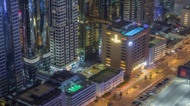 Çatı da yüzme havuzu ile otopark yukarıda gece timelapse, Mali bölge havadan üst görünümü manzaralı. İnsanlar rahatlıyor. Dubai, Birleşik Arap Emirlikleri