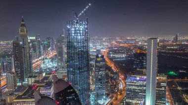 Sheikh Zayed Road ve Difc hava gece zaman aşımına dubai, Bae yakınındaki binaların panoramik silueti. Finans merkezi ve şehir merkezinde modern kuleler ve ışıklı gökdelenler