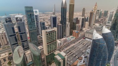 Dubai, Bae'de hızla hareket eden gölgelerile tüm gün boyunca Şeyh Zayed Yolu ve Difc hava saati binalarının siluet görünümü. Finans merkezi ve şehir merkezinde modern kuleler ve gökdelenler