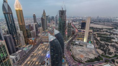 Sheikh Zayed Yolu yakınlarındaki binaların silueti ve Dubai, BAE 'deki hava durumu. Günbatımından sonra finans merkezinde ve şehir merkezinde inşaat alanı olan modern kuleler ve gökdelenler.