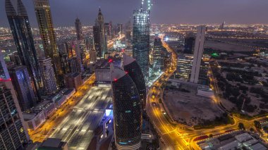 Sheikh Zayed Road ve Difc hava gece zaman aşımına dubai, Bae yakınındaki binaların panoramik silueti. Finans merkezi ve şehir merkezinde modern kuleler ve ışıklı gökdelenler