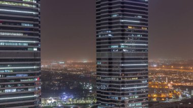 Jumeirah göl kuleleri ofis binaları dubai pencerelerde yanıp sönen ışıkları ile ilçe gece zaman aşımına uğrar. Modern gökdelenler ile yukarıdan havadan görünüm