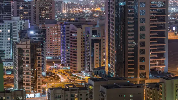 Tecom ilçe gökdelenler Yeşiller ilçe gece timelapse havadan görünümü. Ofis ve konut aydınlatmalı binalar yukarıdan.