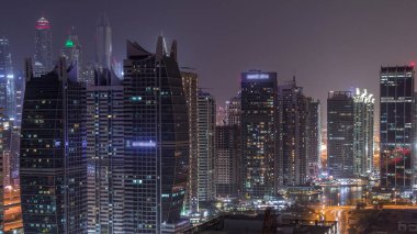 Jumeirah göl kuleleri ilçe dubai gece timelapse konut ve ofis binaları. Modern gökdelenler ile yukarıdan havadan panoramik görünüm