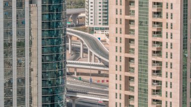 Jumeirah göl kuleleri ilçe dubai ile sabah timelapse konut ve ofis binaları. Modern gökdelenler arasında bir yolda trafik ile yukarıdan havadan panoramik görünümü