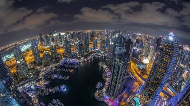 Dubai Marina gökdelenleri ve Jumeirah göl kulelerini aydınlattı ve Birleşik Arap Emirlikleri 'nin en üst düzey hava gece zaman çizelgesinden panoramik görüntüler elde etti. Yolda trafik ve yüzen tekneler.