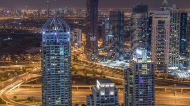 Dubai Marina, gökdelenleri ve Jumeirah göl kulelerini aydınlattı. Birleşik Arap Emirlikleri 'nin en üst düzey hava gece zaman çizelgesinden. Yolda trafik vardı.