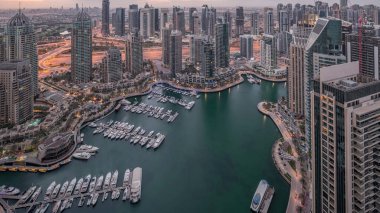 Dubai Marina, gökdelenleri ve Jumeirah göl kulelerini aydınlatmış ve Birleşik Arap Emirlikleri 'nde gece gündüz geçiş zamanlarına kadar panoramik manzara sağlamıştır. Yolda trafik ve yüzen tekneler.