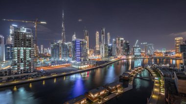 Şehir merkezindeki gökdelenler, Dubai, Birleşik Arap Emirlikleri ile Business Bay 'deki lüks binaların zaman çizelgesiyle parlak bir gecede şehrin havadan panoramik görüntüsü.