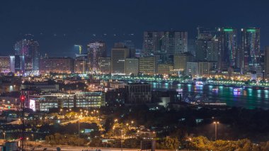 Şehrin güzel manzarası gökdelenlerden gelen ışıklar ve nehir üzerindeki aydınlık yatlarla Deira ve Dubai Nehrinde gece vakti havadan çekilmiş zaman çizelgesi, Birleşik Arap Emirlikleri