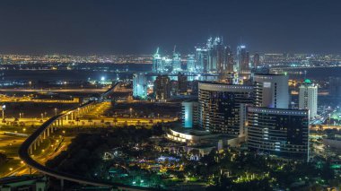 Hava Saati, Dubai, Birleşik Arap Emirlikleri 'nin arka planında, Dubai dere limanında inşa edilen yeni modern binaların ve karayolu ve metro hattının gece görüşü.