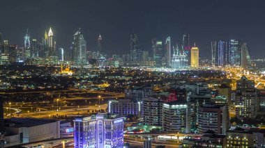 Şehir merkezindeki aydınlık binaların ve gökdelenlerin panoramik hava manzarası ve finans bölgesi Timelapse, sokaklar, Dubai, Birleşik Arap Emirlikleri