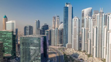 Business Bay, Dubai, Uae 'de birçok kulesi bulunan modern konut ve ofis binası. Körfez Bulvarı Parkı 'nın yanındaki büyük otoparkta arabalar ve trafik vardı.