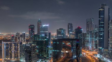 İş hanı gece kuleleri aydınlatıyordu. Kanal yakınlarındaki bazı gökdelenlerin çatı manzarası ve inşaat halindeki yeni kuleler. Kavşağı olan yollarda trafik ve pencerelerde ışıklar