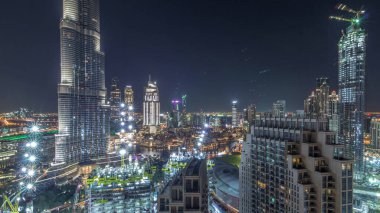 Şehir merkezindeki Dubai 'nin panoramik ufuk çizgisi manzarası. Alışveriş merkezi, çeşmeler ve Burj Halife' nin zaman çizelgesi tüm gece boyunca yanıp sönüyor. Modern ışıklandırılmış gökdelenler ve inşaat alanı