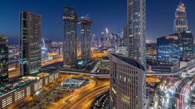Yoğun yolları olan yeni ve yüksek binaların hava manzarası. Dubai 'de günden geceye geçiş. Şehir merkezinden Dubai' ye, Birleşik Arap Emirlikleri.