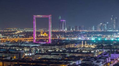 Zabeel Mescidi ile Dubai Çerçeve gece zaman atlamalı aydınlatılmış. Yukarıdan havadan görünüm. Arka planda gökdelenler. Çerçeve Zabeel Park mimari bir dönüm noktası.