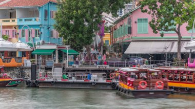 Clarke Quay limanına yanaşan turist tekneleri renkli evlerle dolu. Clarke Quay, Singapur 'un Singapur Nehri Planlama Bölgesi' nde bulunan tarihi nehir kenarı rıhtımıdır..