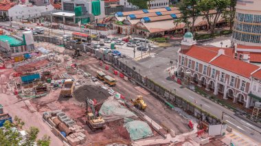 Şehir zaman diliminde büyük bir inşaat sahası, iş yerinde ağır araç, kazıcı ve buldozer, Singapur 'da büyük çaplı inşaat çalışmaları.