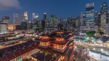 Buddha Diş Kalıntısı Tapınağı Singapur Çin Mahallesi 'nde gece gündüz canlanıyor. Arka planda şehrin silüeti var. Tapınak gökdelenler ve kulelerle aydınlık