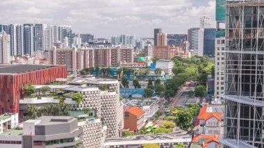 Singapur silueti, Victoria caddesi ve Ulusal Kütüphane hava zaman çizelgesi. Trafiği olan yeşil ağaçlar. Mavi gökyüzünde bulutlar