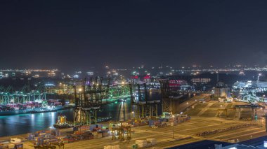 Singapur 'un ticari limanı gece vakti. Asya 'nın en işlek kargo limanının panoramik görüntüsü. Limanda ithalat ve ihracat malları yükleyen yüzlerce gemi ve binlerce konteynır var.