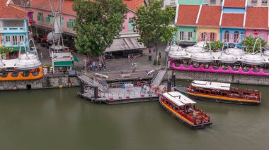 Clarke Quay limanına yanaşan turist tekneleri renkli evlerle dolu havadan zaman ayarlı. Clarke Quay, Singapur 'un Singapur Nehri Planlama Bölgesi' nde bulunan tarihi nehir kenarı rıhtımıdır..