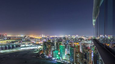 Abu Dabi şehir merkezindeki gökdelenlerle aydınlanan gökdelenler ve cam yüzeye yansıyan gökdelenler.