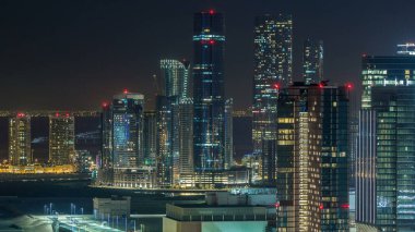 Abu Dabi şehir merkezinin gökdelenleri ve kuleleri aydınlatılmış gökdelenler ve gökdelenlerle dolu gökyüzü çizgisi.