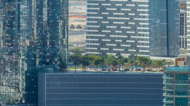 Abu Dabi 'deki Al Reem Adası' ndaki binalar yukarıdan zaman çizelgesi. Al Reem Adası 'nın sabah gökdelenlerin yansımasını gösteren, alışveriş merkezinin çatısındaki bahçe manzarası..