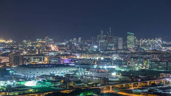 Şehir binalarından ve stadyumdan gelen parlak ışıkların güzel bir görüntüsü. Finansal merkez Dubai 'de, Birleşik Arap Emirlikleri' nde akşam havasında hızlı bir ritmi var.