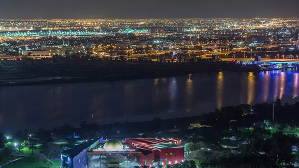 Nehir kenarındaki yolların hava görüntüsü yansımalı ve gece vakti Dubai Deresi, Birleşik Arap Emirlikleri 'nde aydınlatma saatli park.