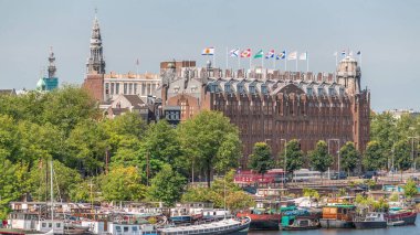 Amsterdam ufuk çizgisi Oosterdok limanındaki teknelerle Scheepvaarthuis hava zaman çizelgesi. Amsterdam Centraal İstasyonu yakınlarındaki geleneksel Hollanda mimarisi. Amsterdam, Hollanda