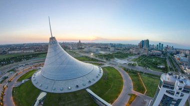 Khan Shatyr ve merkez iş bölgesiyle şehir merkezinin üzerindeki hava manzarası. Gün doğumundan önce geçiş zamanı, Kazakistan, Astana, Orta Asya