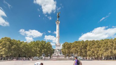 Bordeaux, Fransa 'da Esplanade Des Quinconces zaman ayarlı fıskiyeli Aux Girondins Anıtı. Tarihi eser ve mimari şaheser özgürlüğü ve devrimi simgeliyor. Mavi bulutlu gökyüzü