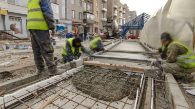 Çelik şebeke takviyesi yaptıktan sonra beton karıştırıcı hiperhızlandırıcı ile yolu açmak için hazır beton dökülüyor. Şehir caddesindeki tramvay raylarının yeniden inşası