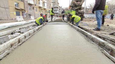 Beton karıştırıcı hızlandırıcı hiperhızlandırıcıyla yolu açmak için çelik takviyesi yaptıktan sonra hazır beton döküp düzleştiriyorlar. Tramvay raylarının yeniden inşası