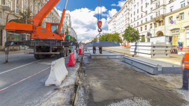 Vinç yol inşaat site timelapse hyperlapse, beton plaka yükleme. Kavganın ve üniforma ile sanayi işçileri. Sokak şehir tramvay yeniden inşası izler